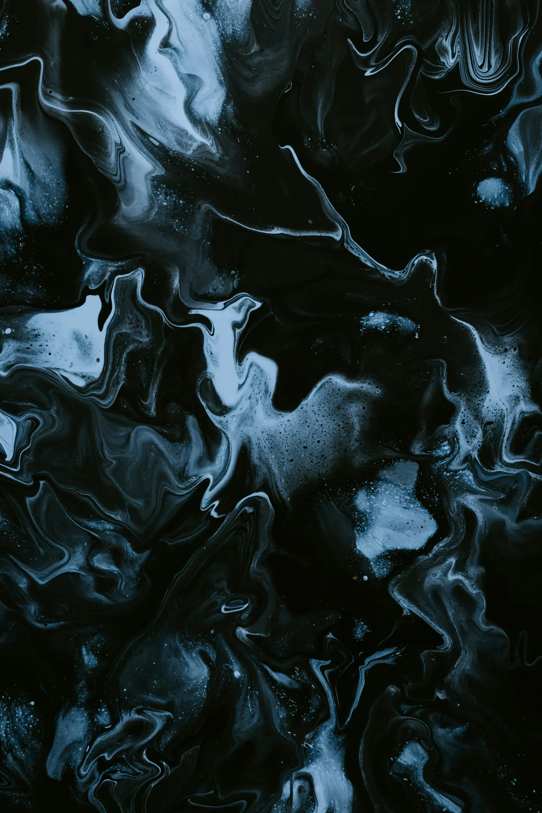Dark blue and black liquid forms flowing in concentrated swirls