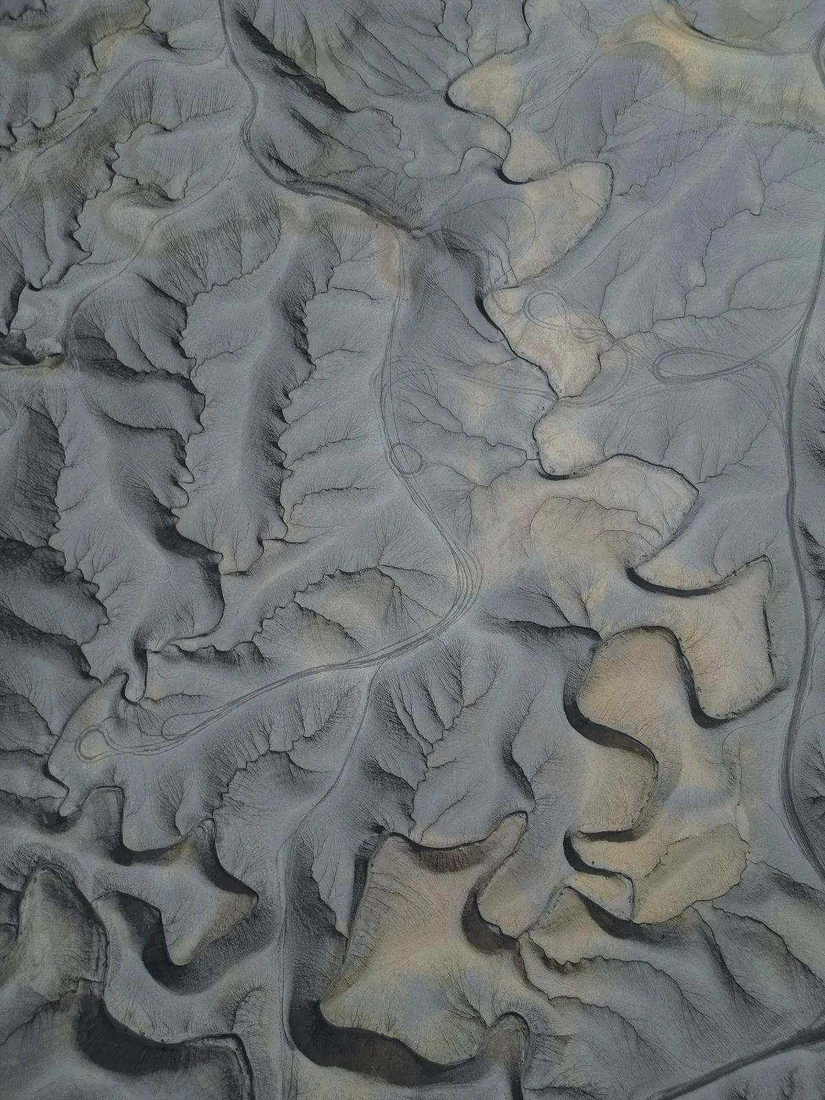 Aerial view of layered desert terrain with flowing natural contours