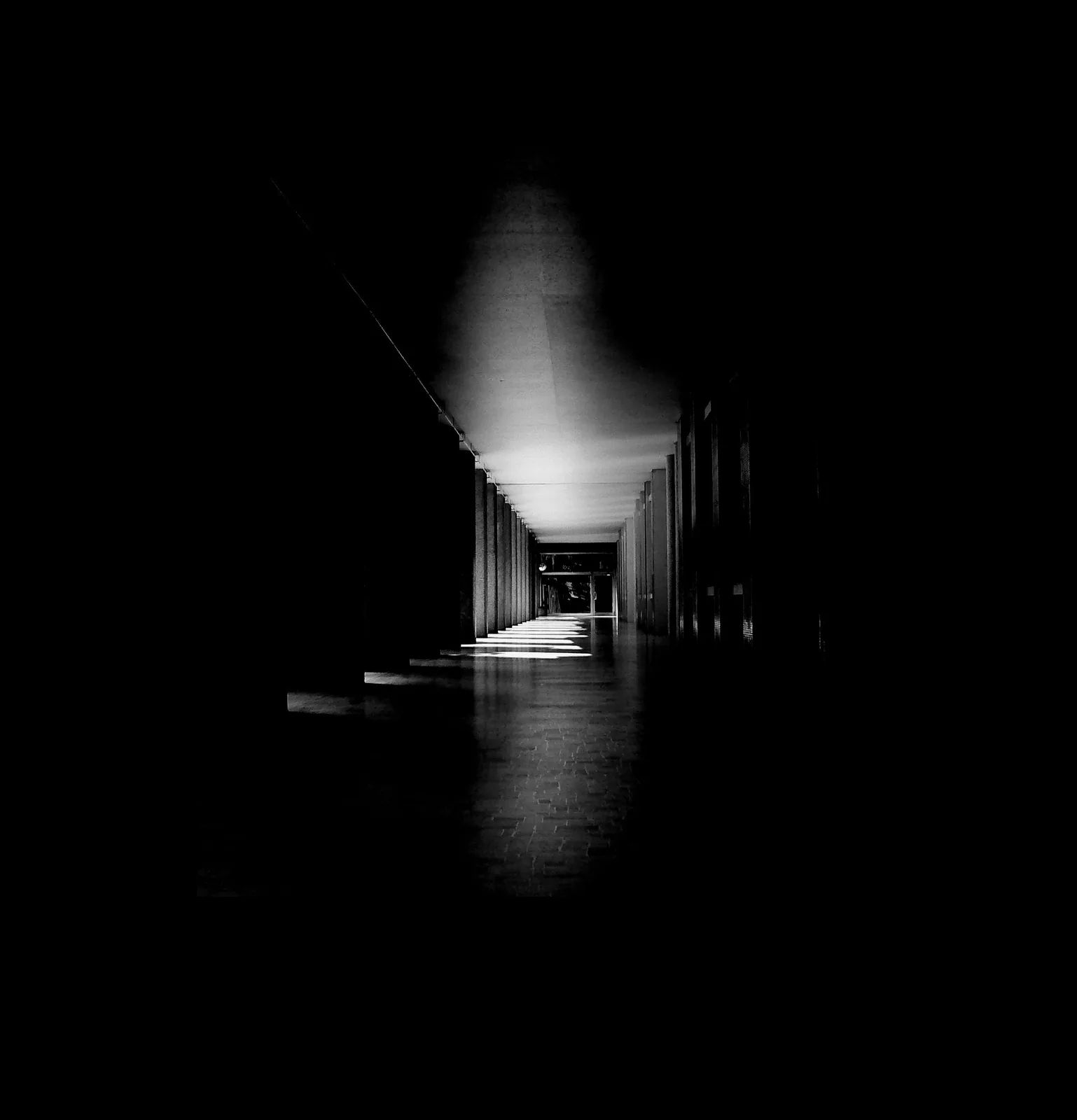 Dark corridor with alternating patches of light and shadow